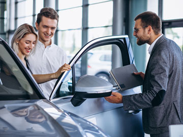 Frau verzweifelt mit Ihren Händen vor dem Setuer Ihres Autos